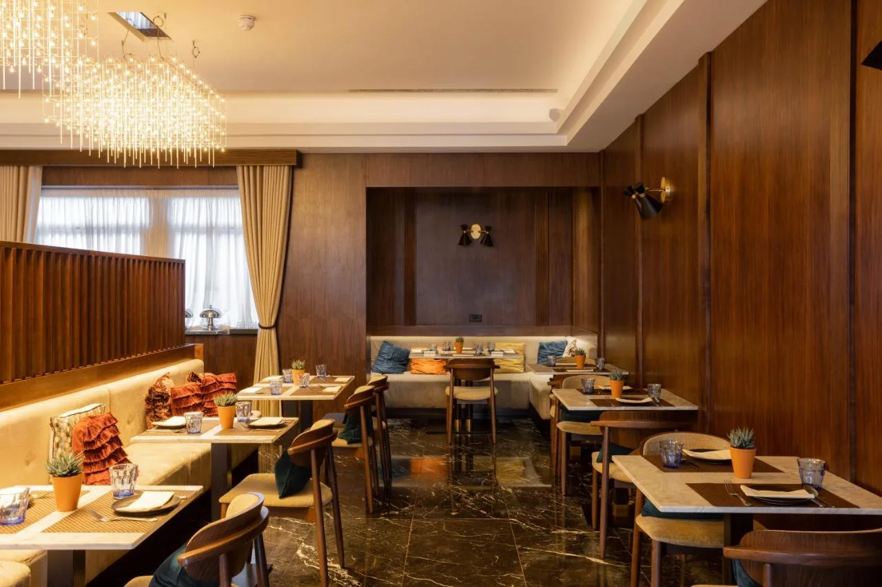 a restaurant with wooden walls and tables and chairs at Montcalm Chilworth Townhouse in London