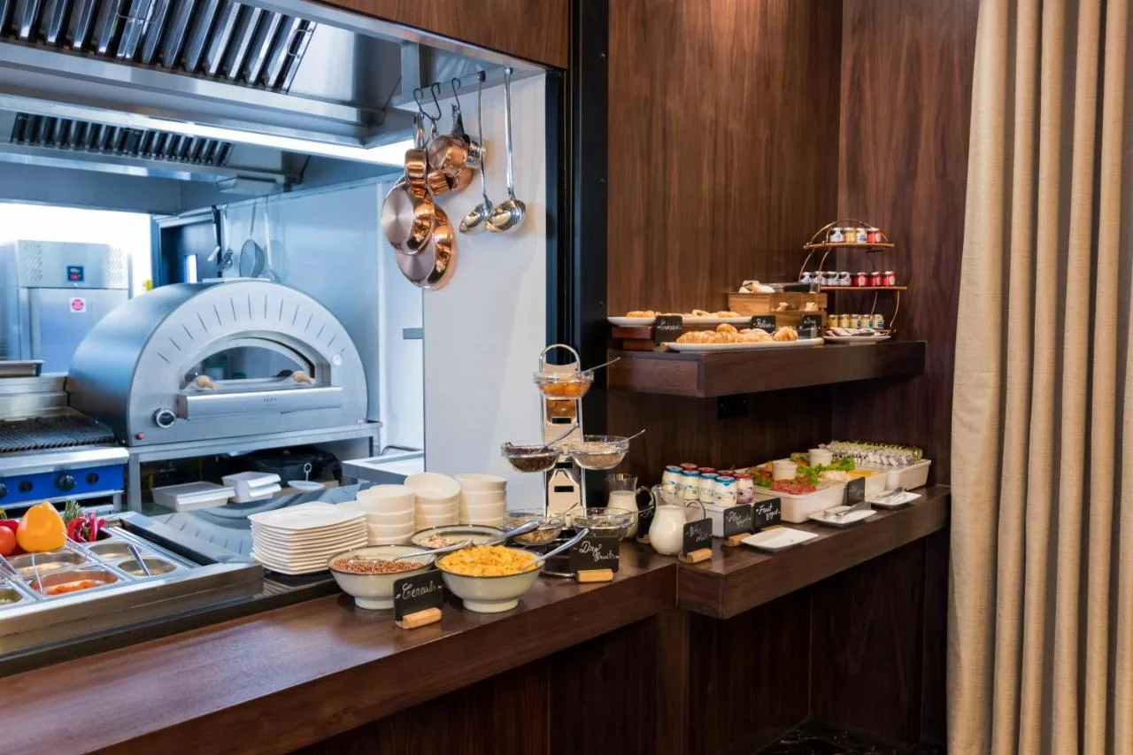 a kitchen with a buffet of food in a restaurant at Montcalm Chilworth Townhouse in London