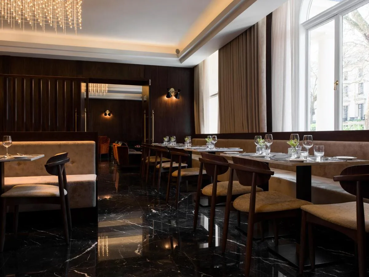 a dining room with tables and chairs and windows at Montcalm Chilworth Townhouse in London